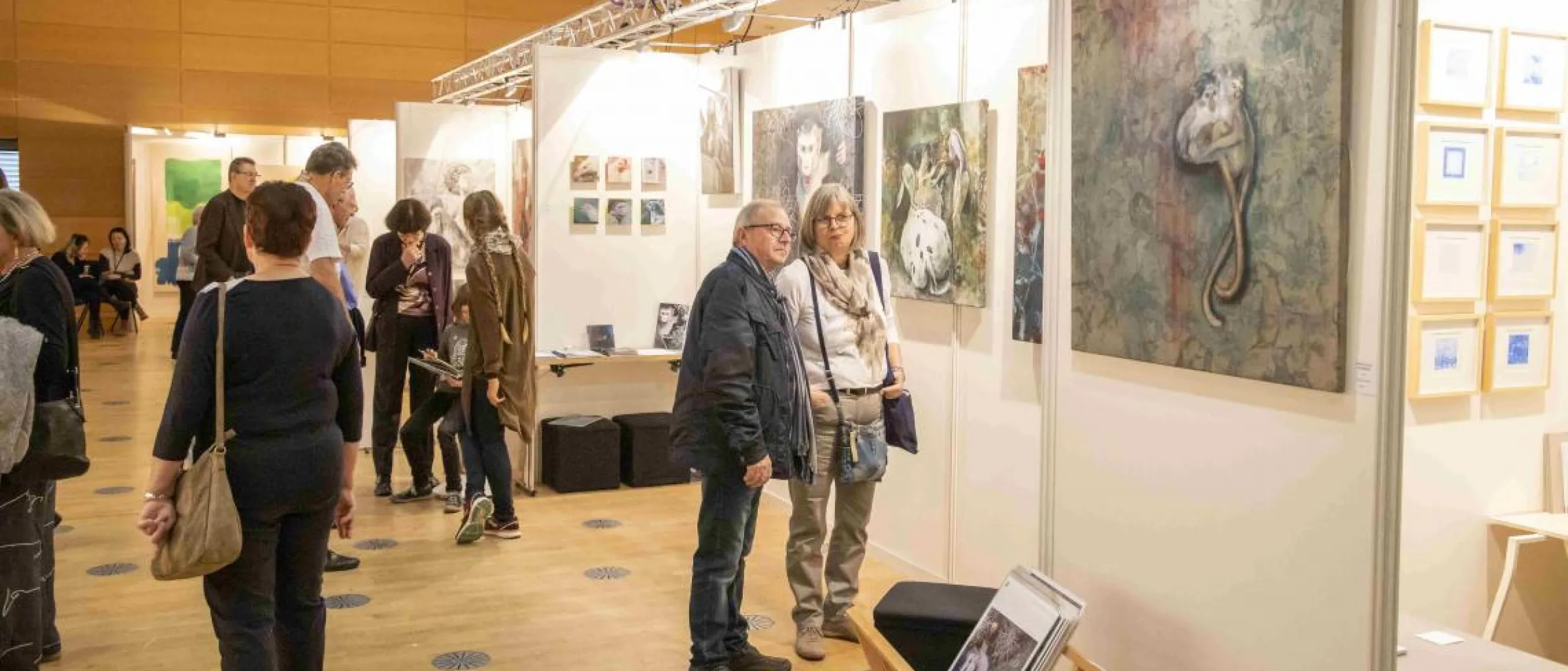 Ein Mann und eine Frau betrachten ein quadratisches Gemälde.