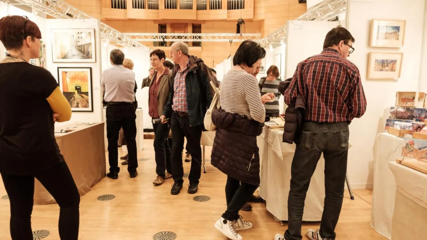 Mehrere Personen betrachten einen Stand auf der Messe.