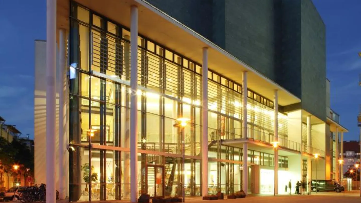 Ein imposantes modernes Gebäude voll beleuchtet bei Nacht.